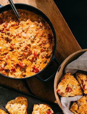 Image of Tomato Southern Gravy in cast iron skillet and tomato cheddar scones in bottom of image